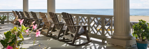 balcony with chairs looking toward the beach and ocean