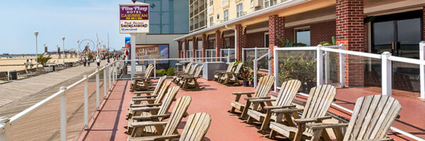 outdoor day view of the front of the hotel, with chairs on the patio